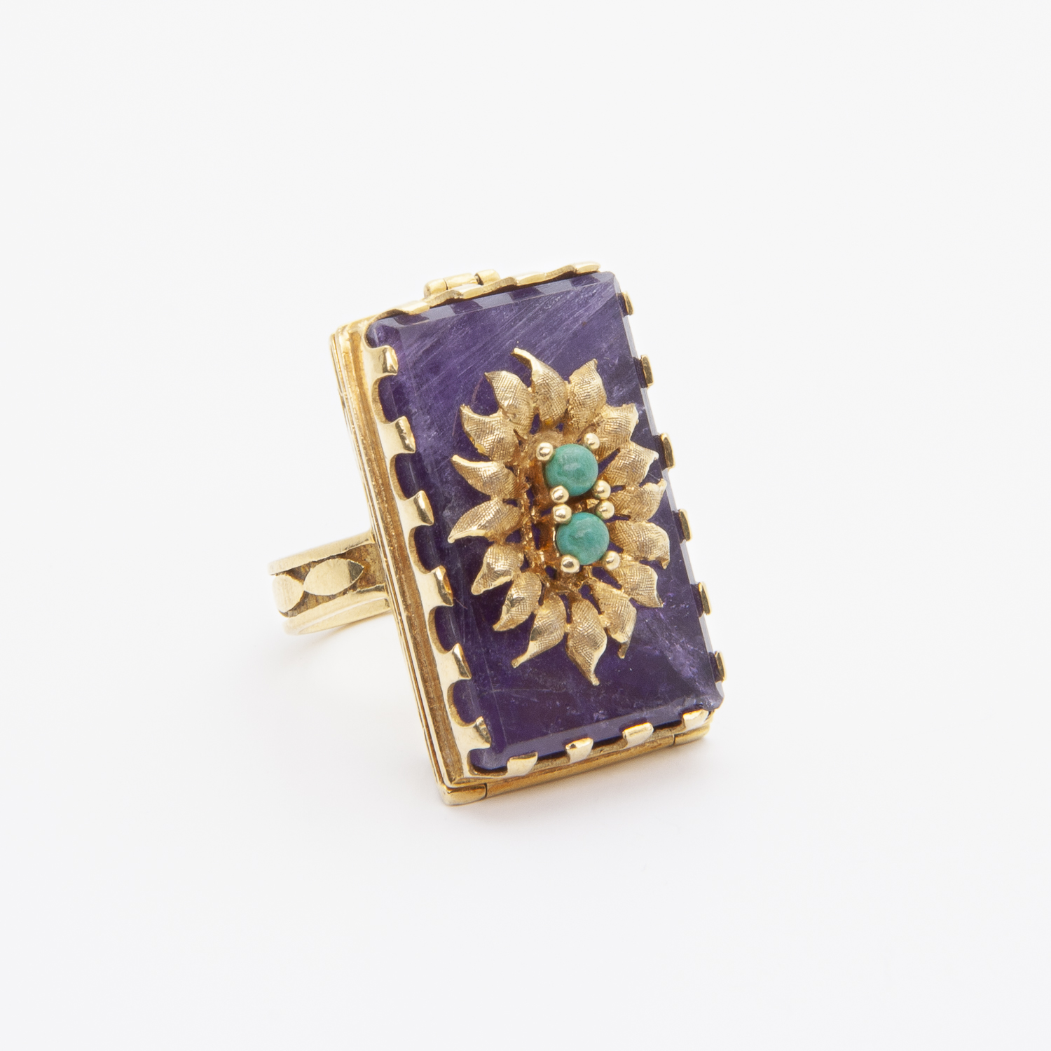 Un anillo de recuerdo de oro amarillo de 18 quilates con amatista y amazonita presenta una gran piedra preciosa violeta rectangular con un diseño floral en cuentas de oro y turquesa en el centro, sobre un fondo blanco liso. Joieria Vintage Barcelona
