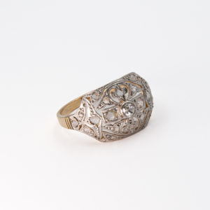 L´Anell Belle Epoque presenta un disseny vintage amb una filigrana de plata elaborada en platí i una pedra preciosa central de diamant rodó. La banda té un elegant acabat en or groc de 18 quirats, fet que realça l'artesania detallada. Joieria Vintage Barcelona