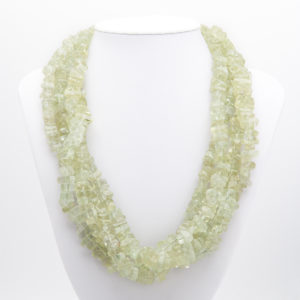 Un collaret anomenat "Collar d'aiguamarina amb fermall d'or 18K de Tiffany de Paloma Picasso", amb perles de textura rugosa de color verd clar disposades en múltiples fils, es mostra en un bust blanc sobre un fons llis. Joieria Vintage Barcelona