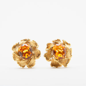 Los Pendientes de oro y zafiro naranja son pendientes de oro de diseño intrincado con piedras preciosas de ámbar centrales, que se asemejan a pétalos florales alrededor de las piedras sobre un fondo blanco liso. Joieria Vintage Barcelona