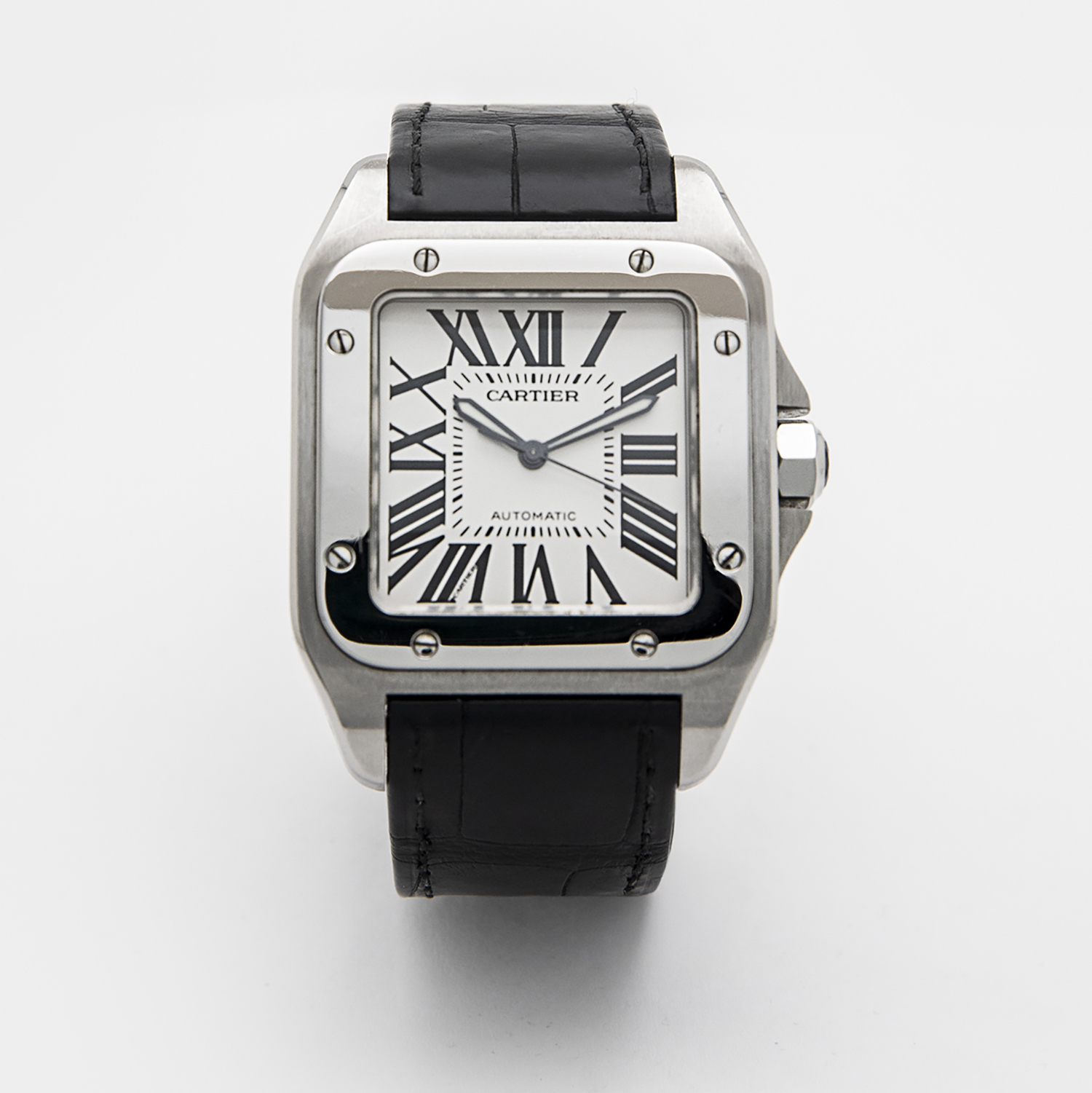 El Cartier Santos 100 XL compta amb un bisell quadrat platejat, una esfera blanca amb números romans negres i agulles platejades. Inclou una corretja de pell negra i porta la inscripció "Cartier" i "Automàtic" a l'esfera. Joieria Vintage Barcelona