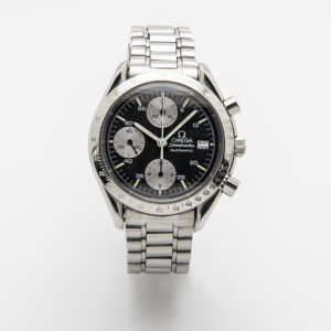 Omega Speedmaster platejat amb cara fosca, subesferes platejades, braçalet de metall; característiques incloses marcadors de minuts, hores i segons, tres subesferes i text "Omega Speedmaster Automatic" a la cara. Joieria Vintage Barcelona