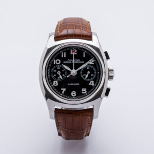 El Girard-Perregaux Vintage 1970 Nº 1083 és un rellotge de polsera de luxe amb esfera negra, caixa platejada, corretja de pell marró, números platejats, dues subesferes i el nom de la marca a l'esfera. Joieria Vintage Barcelona