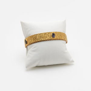 Pulsera vintage de oro de 18 quilates con tres gemas hexagonales de iolita, expuestas en un cojín blanco sobre un fondo blanco liso. Joieria Vintage Barcelona